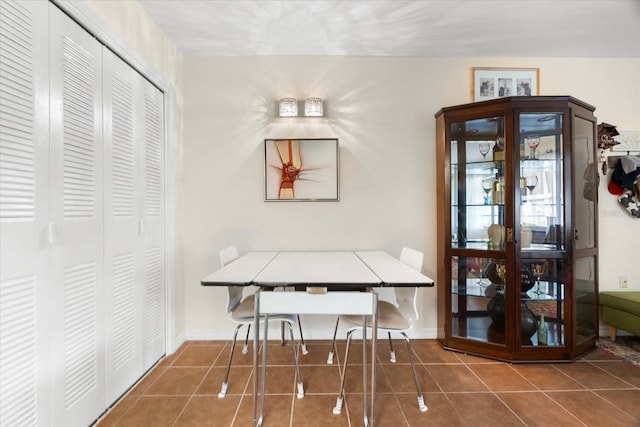 dining area featuring dark tile patterned flooring