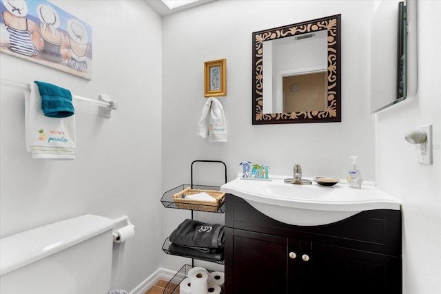 bathroom with vanity, a skylight, and toilet