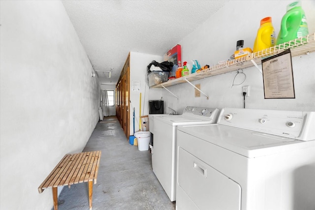 washroom with washer and dryer and a textured ceiling