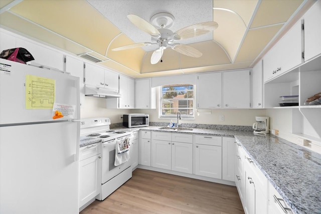 kitchen featuring sink, white cabinetry, light stone counters, a raised ceiling, and white appliances