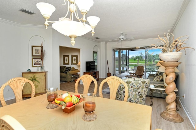 dining space with crown molding, ceiling fan with notable chandelier, hardwood / wood-style floors, and a textured ceiling