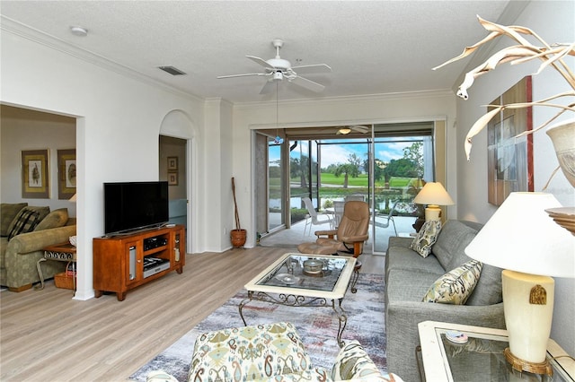 living room with crown molding, ceiling fan, light hardwood / wood-style floors, and a textured ceiling