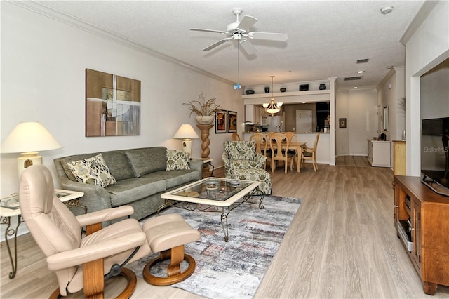 living room featuring crown molding, light hardwood / wood-style flooring, and a textured ceiling