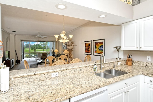 kitchen with sink, white cabinetry, hanging light fixtures, white dishwasher, and light stone counters