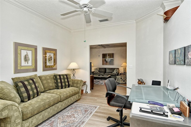 home office featuring ceiling fan, ornamental molding, a textured ceiling, and light wood-type flooring