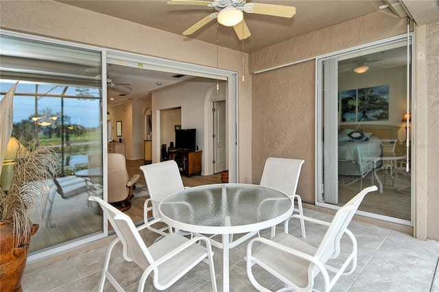 view of patio / terrace with ceiling fan and glass enclosure