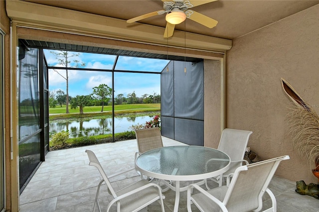 sunroom / solarium featuring a water view and ceiling fan