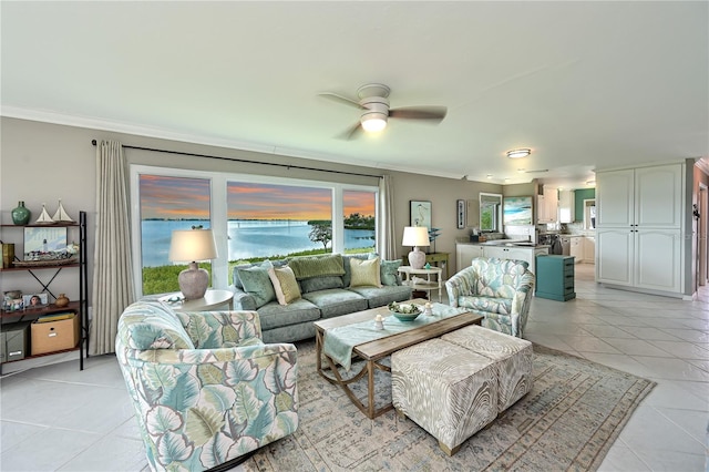 living room with ceiling fan, ornamental molding, and light tile patterned floors