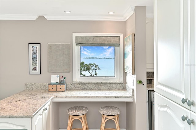 kitchen featuring crown molding, white cabinets, and light stone counters