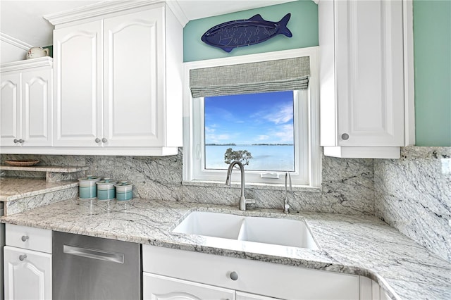 kitchen featuring tasteful backsplash, light stone countertops, sink, and white cabinets