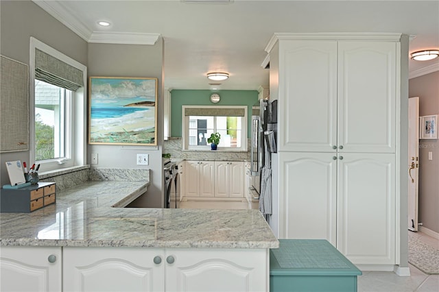 kitchen featuring white cabinetry, kitchen peninsula, and light stone counters