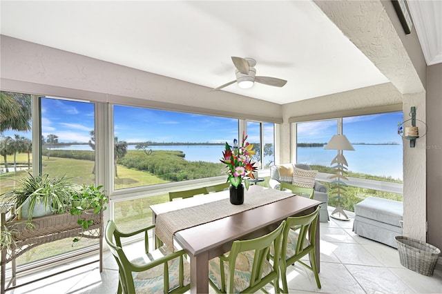 sunroom with a water view and ceiling fan