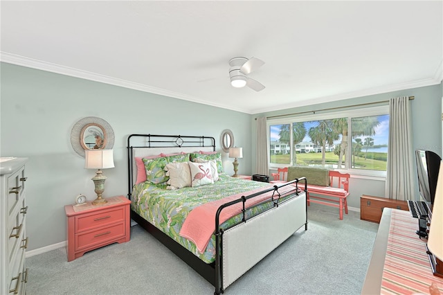 carpeted bedroom with ornamental molding and ceiling fan