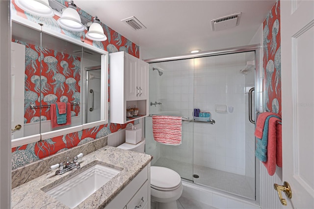 full bathroom with a stall shower, visible vents, vanity, and toilet