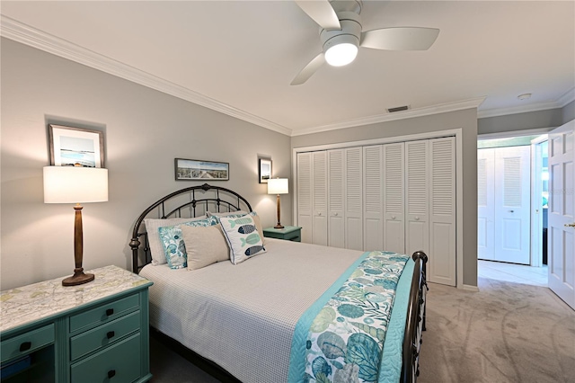 bedroom with ceiling fan, light colored carpet, visible vents, ornamental molding, and a closet