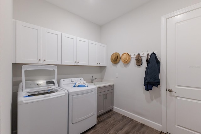 clothes washing area with cabinets, dark hardwood / wood-style flooring, sink, and independent washer and dryer