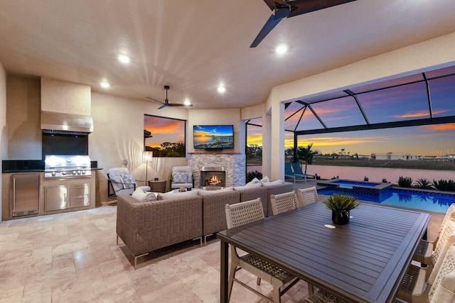 view of patio / terrace featuring ceiling fan, an outdoor living space with a fireplace, glass enclosure, a grill, and area for grilling