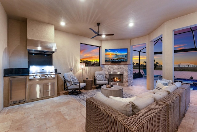 living room featuring ceiling fan and an outdoor stone fireplace