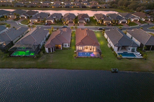 aerial view at dusk featuring a water view