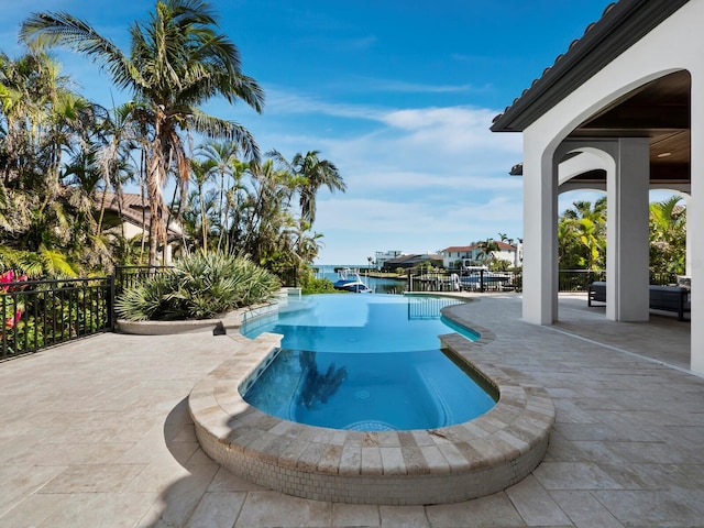 view of swimming pool featuring a patio and a water view