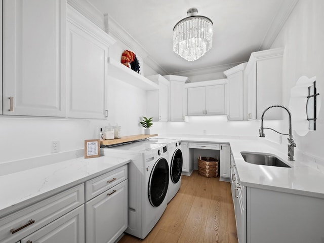 washroom with sink, crown molding, cabinets, light wood-type flooring, and washer and clothes dryer