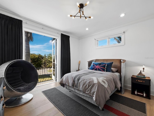 bedroom featuring multiple windows, ornamental molding, access to exterior, and light hardwood / wood-style floors