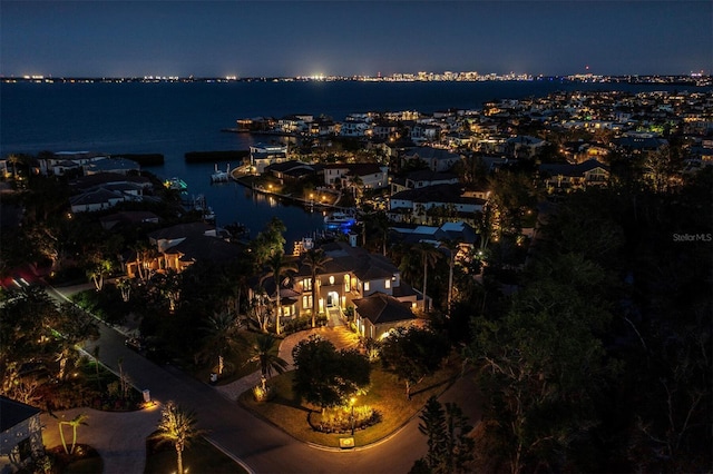 aerial view at night featuring a water view