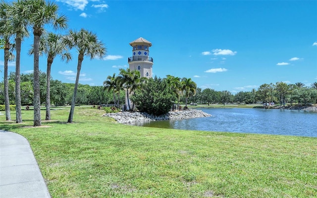 surrounding community featuring a water view and a lawn