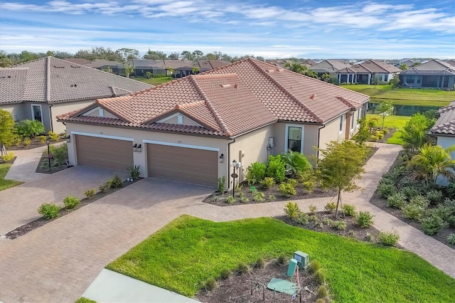 mediterranean / spanish-style home featuring a garage and a front yard