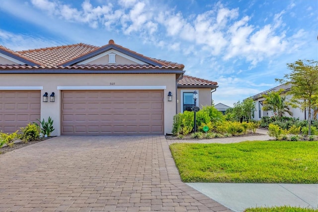 mediterranean / spanish house with a garage and a front yard