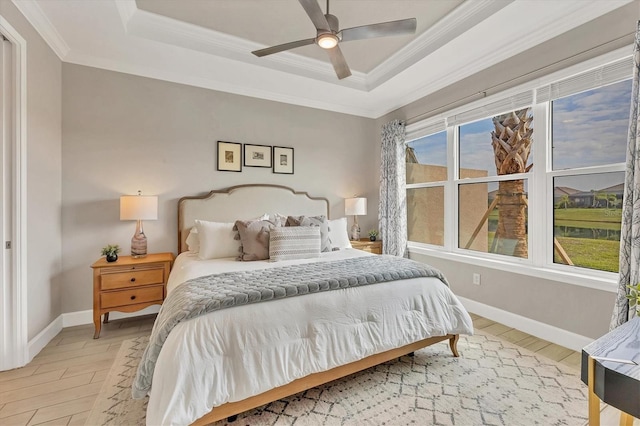 bedroom featuring hardwood / wood-style flooring, ornamental molding, and a tray ceiling