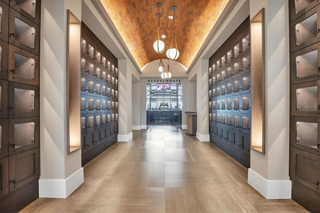 entrance foyer featuring brick ceiling, lofted ceiling, mail boxes, and light wood-type flooring