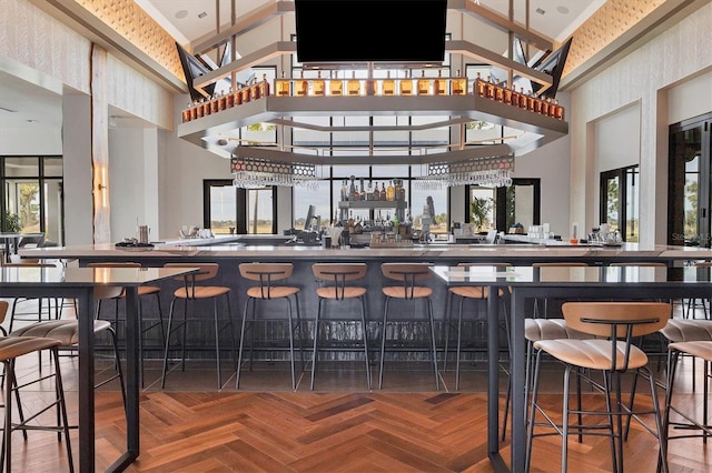 bar featuring parquet flooring and a towering ceiling