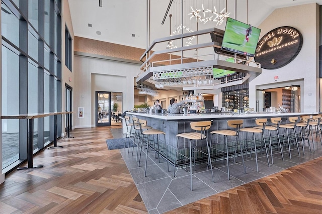 bar with a towering ceiling and parquet flooring