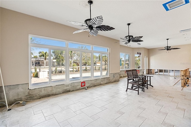 sunroom / solarium featuring ceiling fan