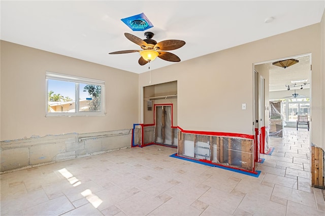 empty room featuring a healthy amount of sunlight and ceiling fan