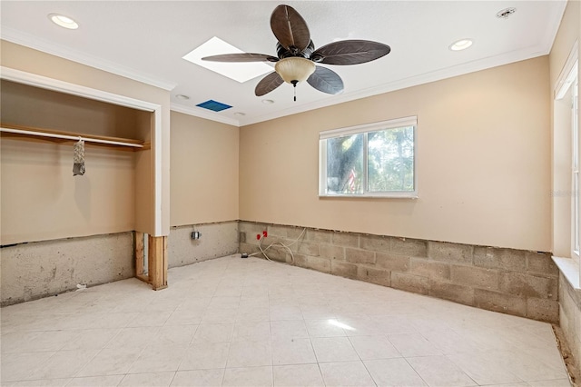 unfurnished bedroom featuring ceiling fan, ornamental molding, a skylight, and a closet