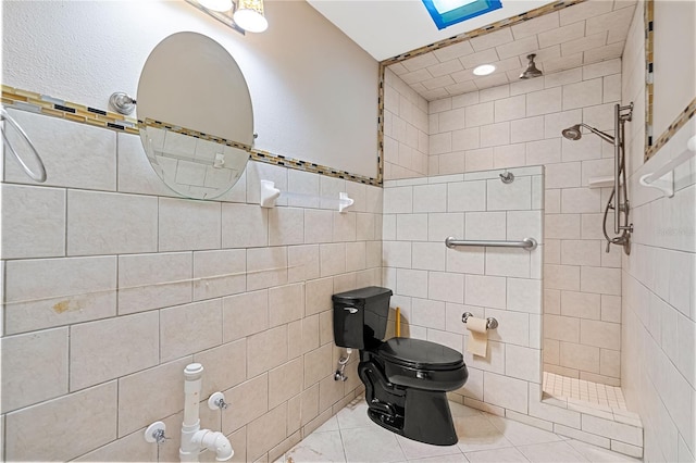 bathroom featuring tiled shower, tile patterned floors, toilet, and tile walls