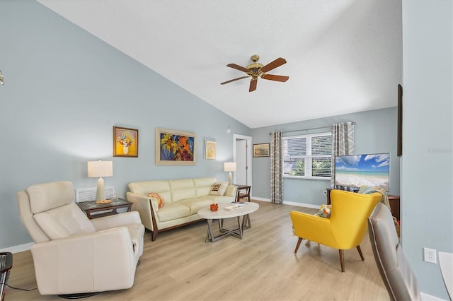 living room featuring a textured ceiling, vaulted ceiling, light hardwood / wood-style floors, and ceiling fan