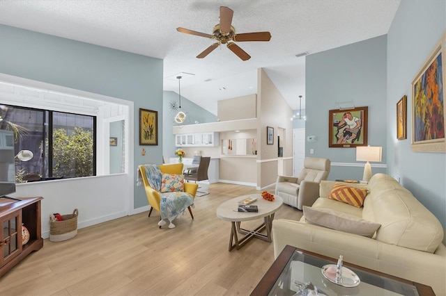 living room with lofted ceiling, a textured ceiling, ceiling fan, and light hardwood / wood-style flooring