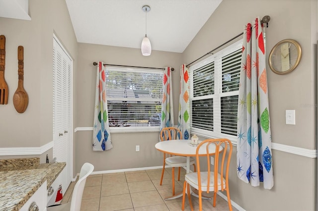 dining space featuring lofted ceiling and light tile patterned floors