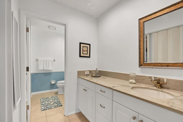 bathroom featuring tile patterned floors, toilet, vanity, and a textured ceiling