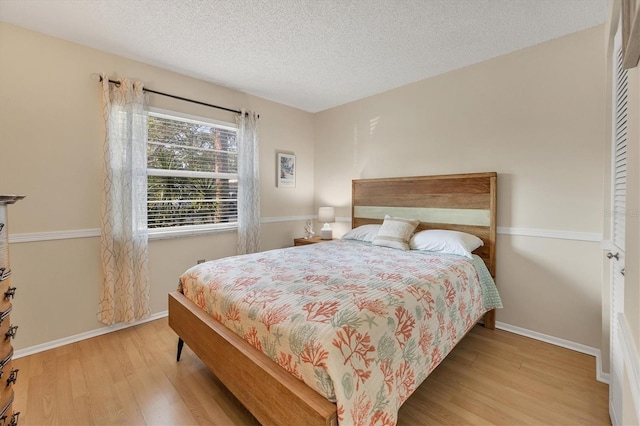 bedroom featuring a textured ceiling and light hardwood / wood-style floors