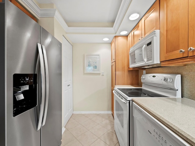 kitchen featuring light tile patterned floors, crown molding, white appliances, a tray ceiling, and light stone countertops