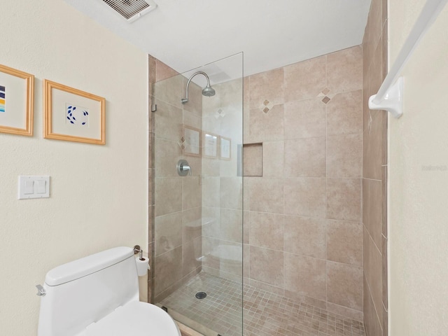 bathroom featuring toilet and a tile shower