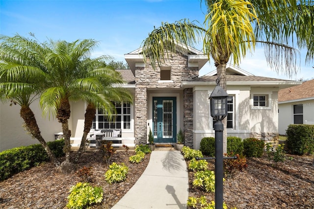 entrance to property featuring stone siding and french doors