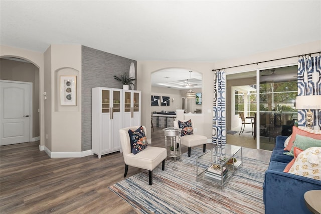 living room with baseboards, arched walkways, and wood finished floors