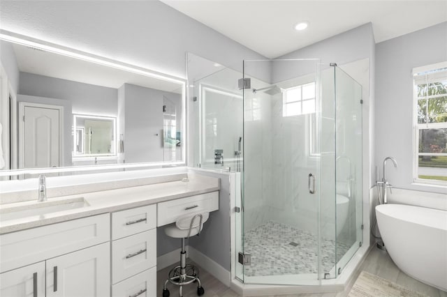 full bath with a freestanding tub, a shower stall, and vanity