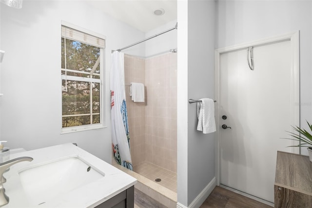 bathroom featuring a stall shower, vanity, and wood finished floors