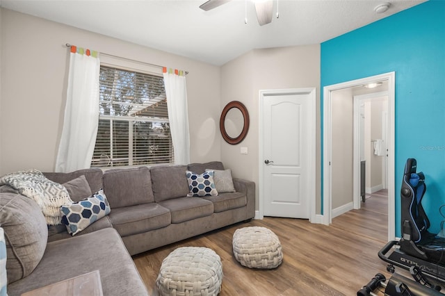 living area with wood finished floors, a ceiling fan, and baseboards